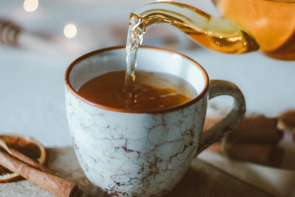 Cup of orange cinnamon tea rich in antioxidants and immune-boosting properties.